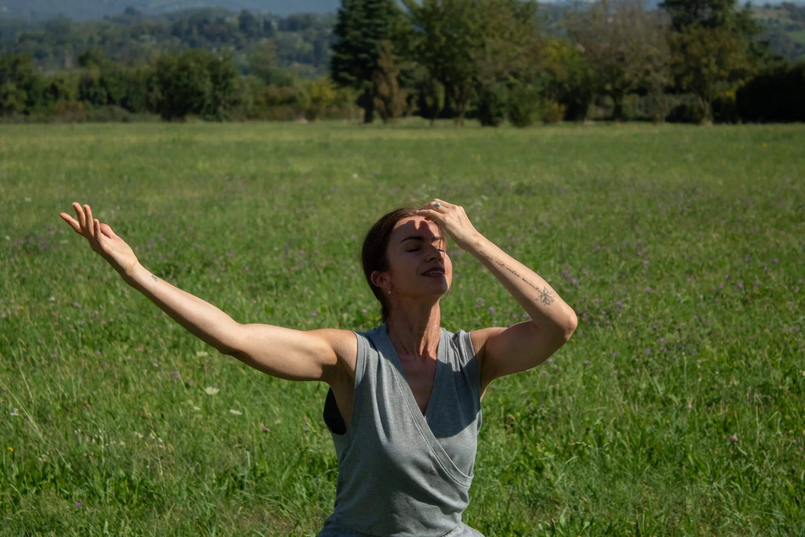 Barbara danza a occhi chiusi in un prato, le braccia sollevate